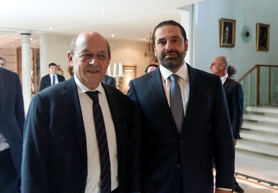 A picture taken with a cell-phone on November 16, 2017, shows French Foreign Minister Jean-Yves Le Drian posing for a photo with Lebanese Prime Minister Saad Hariri in the Saudi capital Riyadh. / AFP PHOTO / Valérie LEROUX