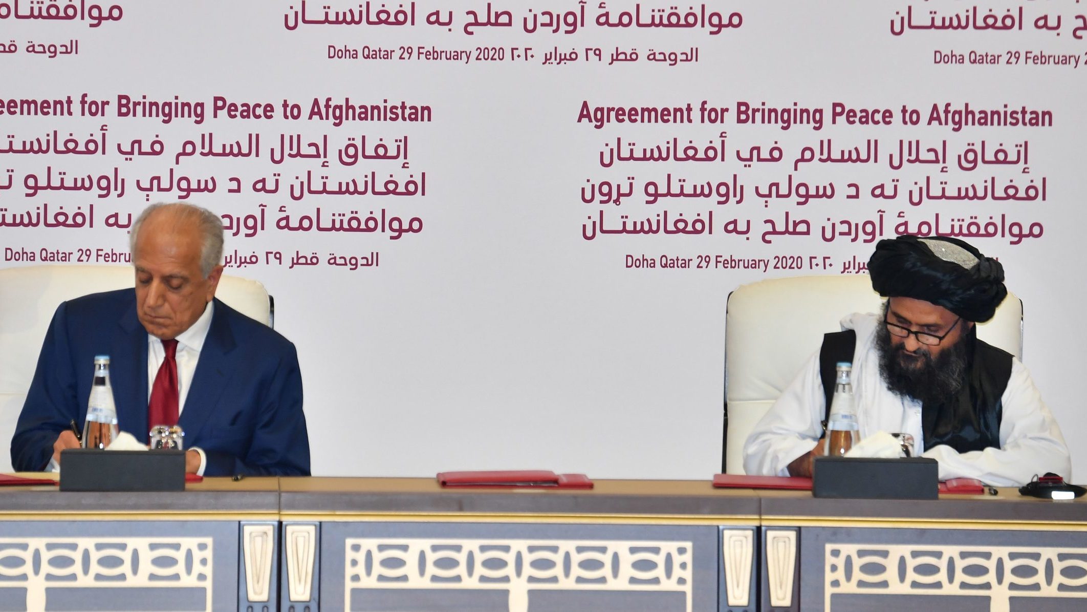 (L to R) US Special Representative for Afghanistan Reconciliation Zalmay Khalilzad and Taliban co-founder Mullah Abdul Ghani Baradar sign a peace agreement during a ceremony in the Qatari capital Doha on February 29, 2020. - The United States signed a landmark deal with the Taliban, laying out a timetable for a full troop withdrawal from Afghanistan within 14 months as it seeks an exit from its longest-ever war. (Photo by Giuseppe CACACE / AFP) (Photo by GIUSEPPE CACACE/AFP via Getty Images)