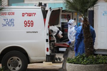 Magen David Adom workers wearing protective clothing, as a preventive measure against the coronavirus evacuating a woman with suspicion for Coronavirus at Hadassah Ein Karem hospital, in Jerusalem, on March 22, 2020. Photo by Flash90 *** Local Caption *** àç
àçéí
øåôà
îðäì
áéú äçåìéí
áéú çåìéí
äãñä
äãñä òéï ëøí
îçì÷ä
îåãã
çåí
ëðñéä
ùåîø
îá÷ø
åéøåñ
÷åøåðä
øôåàä
ôéðåé
àéùä
îáåâøú