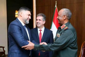 Abdel Fattah Burhan, Head of Sudan's TMC, shaking hands with one of the members of the Israeli delegation led by the FM Elie Cohen (M)