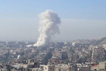 Plumes of smoke billowing from residential edifices in the Mezzeh, Syria